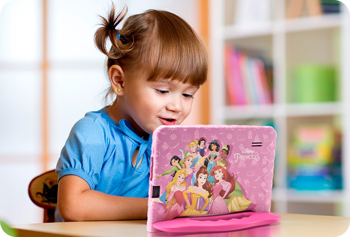 Criança sorridente usando o Tablet Princesas.