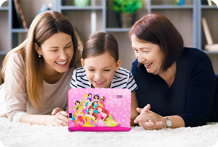 Imagem de uma mãe, a avó e a filha mexendo deitadas mexendo no Tablet Princesas.